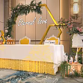 Banquet Hall Interior With Hexagon Floral Arch Yellow Chairs And White Table Skirt