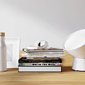 Stylish Decorative Accessory Set With White Bottle Photo Frame Stacked Books Headphones And Modern Lamp