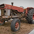 Classic Red SATTO Vintage Tractor With Large Tires And Red Rims On Dirt