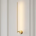 Modern Gold Wall Sconce With Soft Lighting On White Paneled Wall