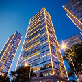Modern High Rise Residential Building With Glass Curtain Wall And Night Lighting