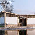 Modern Public Restroom Building With Wooden Accents Stone Base And Trees By Water