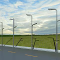 Modern Outdoor Street Lights Along Road With Green Grass And Clear Sky