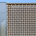 Modern Storefront Facade With Golden Perforated Panels Glass Doors Stone Steps And Water Feature