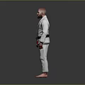 Man in White Judo Uniform with Black Belt Standing Against Gray Background