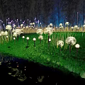 Dandelion Shaped Outdoor Lights with White Glow on Green Grass and Water Reflections at Night
