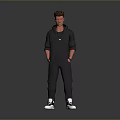Man Standing in Black Hoodie and Pants with Hands in Pockets White Sneakers Gray Background