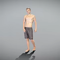 Shirtless Man Standing Barefoot in Gray Shorts Against Gray Background