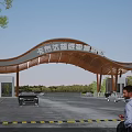 Scenic Entrance Gate with Curved Wooden Roof and Parking Area Featuring Cars and Pedestrians