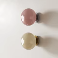 Two Round Pink Beige Wall Lamps With Silver Gold Bases On White Wall