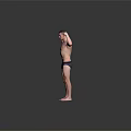 A Man Flexing Muscles Shirtless In Dark Underwear Standing Against Gray Background