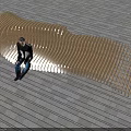 Wooden Curved Slatted Outdoor Chair In Modern Outdoor Setting With Stone Floor
