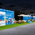 Scenic Outdoor Event Space With Triangular Tent Wooden Deck Tables Chairs Umbrellas And Grassy Area