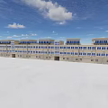Modern Commercial Building Exterior With Multiple Windows And Open White Ground Under Blue Sky
