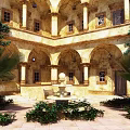 Ancient Architecture Courtyard Featuring Arched Doorways Columns Central Fountain Palm Trees And Lush Shrubs