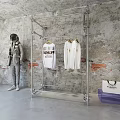 Metal Clothing Display Rack With Hanging Shirts And Astronaut Model By Concrete Wall