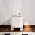 White Bedside Table With Two Drawers Round Legs Lamp Books On Wooden Floor Sunlight Shadows