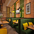 Restaurant Interior With Red Slogan Yellow Pendant Lights Wooden Tables Green Seats And Wall Decorations