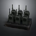 Multiple Black Walkie Talkies Charging On Desktop Dock Station For Communication