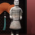 Terracotta Warrior Sculptures Kneeling And Standing With Red Fan And Dark Frame On Wooden Table