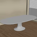 Oval White Dining Table In Light Room With Wooden Floor And Window Blinds