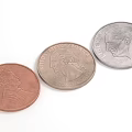 Three US Coins With Copper And Silver Colors And Portraits On White Background