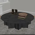 Round Black Coffee Table On Gray Rug With Small Sculptures Wooden Tray And Stacked Books