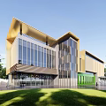 Modern Kindergarten Building Featuring Glass Windows Green Entrance Front Sign And Trees Around
