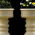 Roadside Stone Flower Planters With Intricate Carvings Holding Greenery And Yellow Blooms