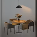 Round Wooden Table And Gray Chairs With Vase Of Flowers And Hanging Black Pendant Light
