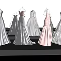 Elegant White And Pink Formal Dresses On Mannequins With Long Flowy Skirts
