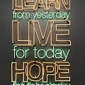 Decorative Lights Forming Learn from Yesterday Live for Today Hope for Tomorrow on Gray Wall