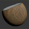 Halved Coconut With White Flesh And Brown Outer Shell On Dark Surface