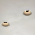 Modern Downlights with Beige Edges and Black Openings Installed on White Slightly Rough Ceiling