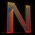 Illuminated 3D Letter N Design With Yellow And Red Neon Lights On Black Background