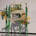 Modern Bamboo Decorative Structure With Yellow Flowers Green Plants Against Gray Wall