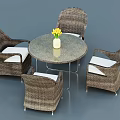 Round Outdoor Table with Wicker Chairs and White Cushions and Vase with Yellow Flowers