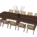 Long Wooden Dining Table with Eight Rattan Back Chairs and Black Decorative Vase