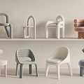 Various Modern Children's Chairs With Pastel Colors And Minimalist Designs Arranged On Shelves