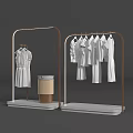 Art Installation Featuring Golden Frame Clothing Racks With White Garments And Lamp Display Stand