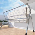 Metal Clothes Drying Rack With Hanging Shirts Jeans And Floral Blanket On Balcony