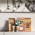 Coffee Paper Bags With Cups Beans And Packaging On White Counter