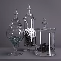 Clear Glass Vases With Lids Containing Decorative Balls And Pebbles On Gray Surface