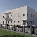 Modern Industrial Factory Building Featuring Blue Roof Surrounding Greenery And Parking Area