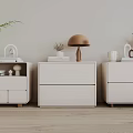 Modern White Bedside Tables With Lamp Books Plants Vases And Decorative Items
