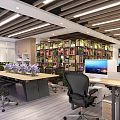 Modern Public Office Space Featuring Long Table Purple Flowers Black Office Chairs Bookshelves Green Plants