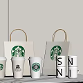 Starbucks Coffee Cups Display With Branded Paper Bags And White Tabletop Arrangement