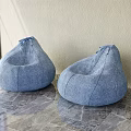 Two Blue Denim Bean Bag Chairs on Gray Marble Floor with Light Colored Wall