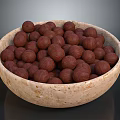 Natural Beige Stone Bowl Filled With Brown Nuts Against Dark Background