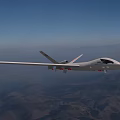 High Altitude Fighter Jet Flying Over Mountainous Terrain With Clear Sky